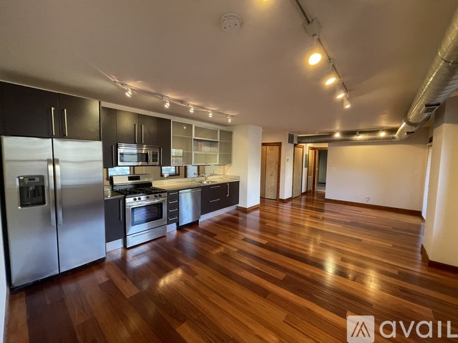 A kitchen with wooden floors and stainless steel appliances.