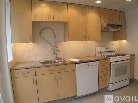 A kitchen with wooden cabinets and a white dishwasher.