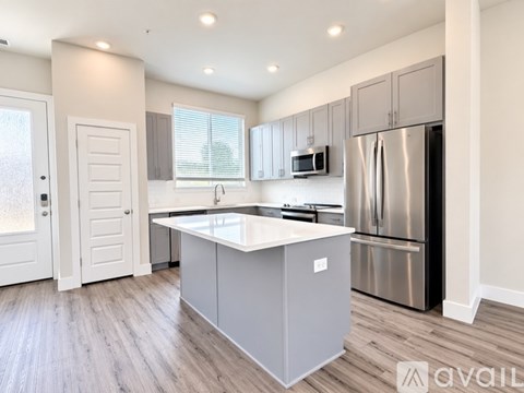 A modern kitchen with a large island and stainless steel appliances.