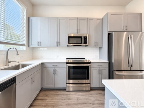 A modern kitchen with stainless steel appliances and white cabinets.