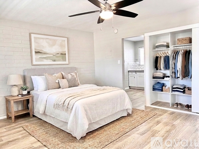 A bedroom with a large bed and a ceiling fan.
