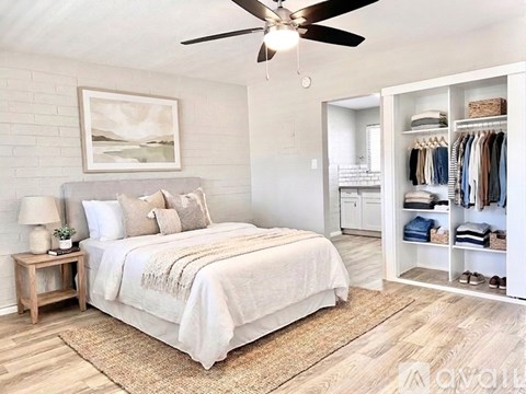 A bedroom with a large bed and a ceiling fan.