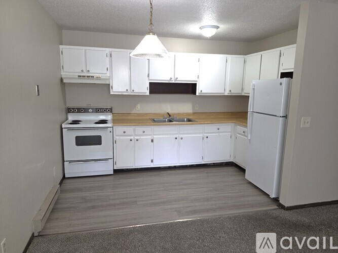 A kitchen with white appliances and cabinets.