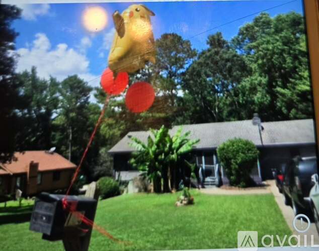 A yellow kite with red circles is flying in the sky.