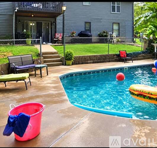 A pool with a red bucket and a blue pool float.