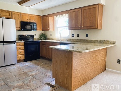 A kitchen with wooden cabinets and a granite countertop.