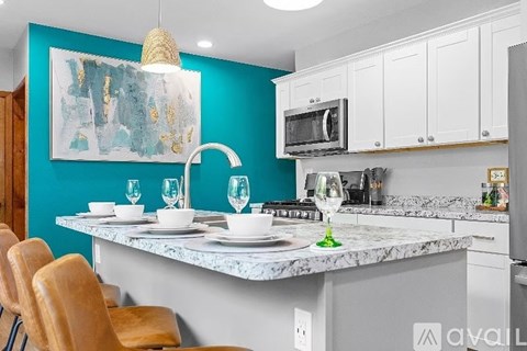 A kitchen with a blue wall and a marble countertop.