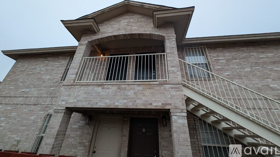 A house with a balcony and a staircase leading to the second floor.