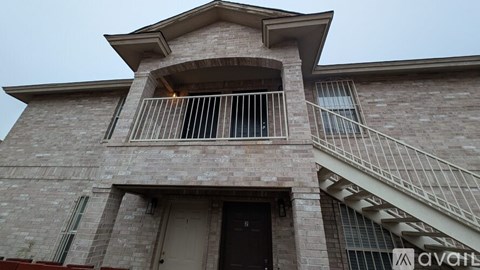 A house with a balcony and a staircase leading to the second floor.