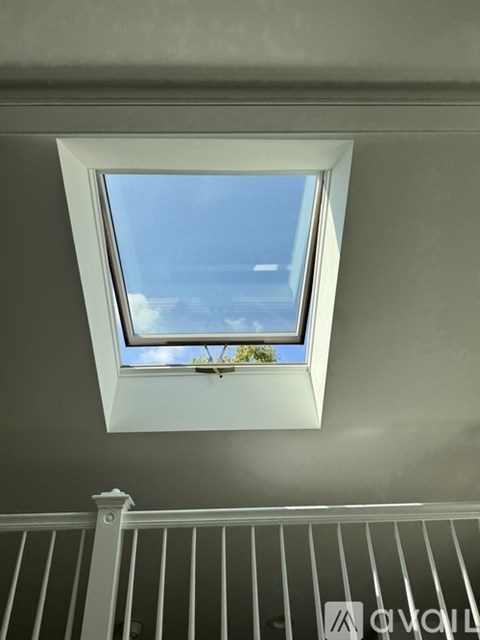 A window in a room with a view of the sky and some trees.
