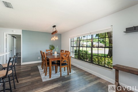 A dining room with a wooden table and chairs.