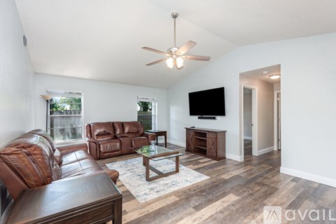A living room with a brown leather couch and a wooden coffee table.