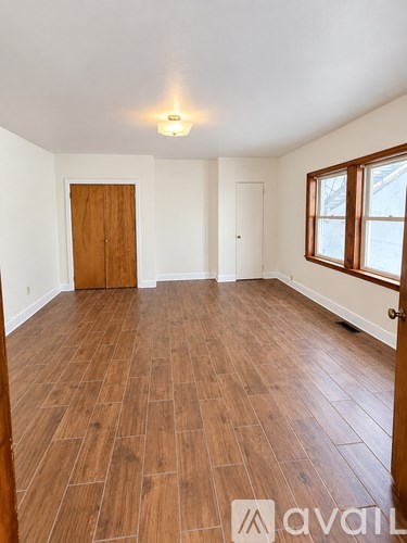 A room with wooden flooring and a window.