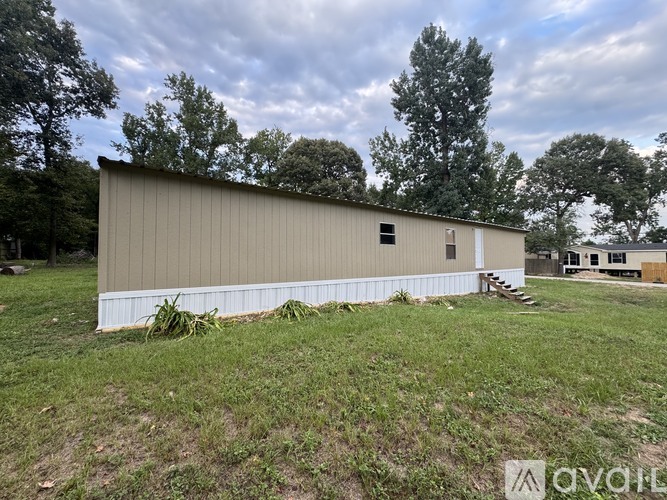 A large metal building with a white trim and a small porch.