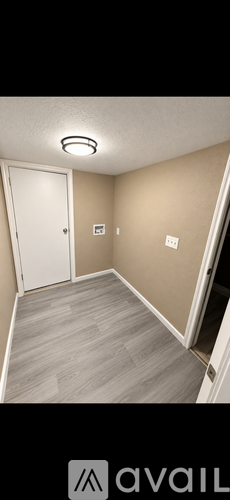 A room with a white door and a light on the ceiling.