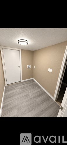 A room with a white door and a light on the ceiling.