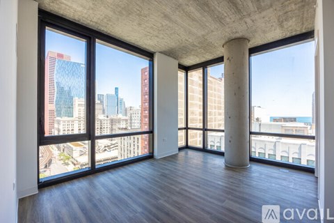 A large empty room with a view of the cityscape outside the windows.