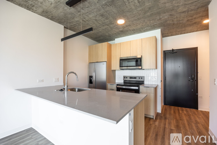 A kitchen with a black refrigerator and a stove top oven.