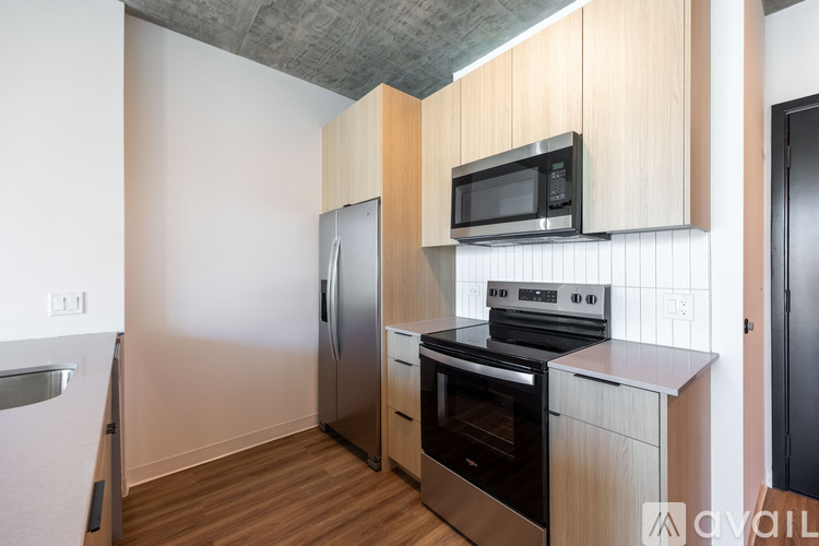 A kitchen with a stainless steel refrigerator, oven, and microwave.