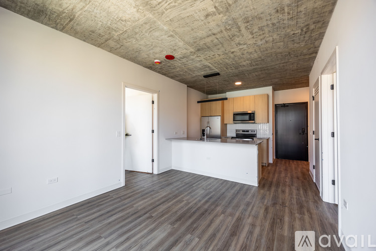 A spacious room with a kitchen area and a ceiling with a textured surface.