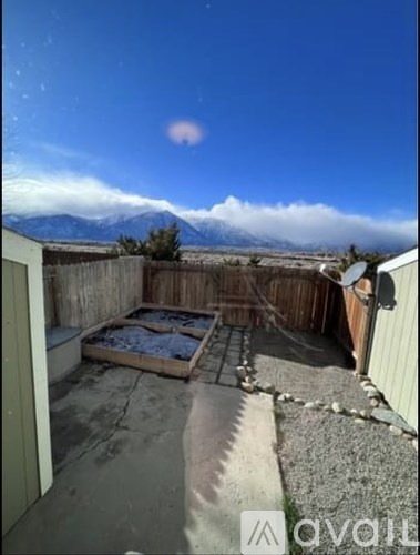 A backyard with a hot tub and mountains in the background.