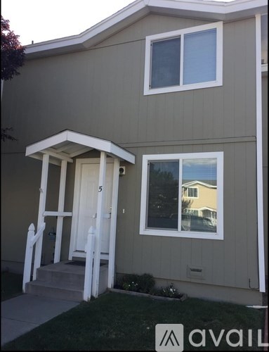A house with a beige exterior and a white door and window.