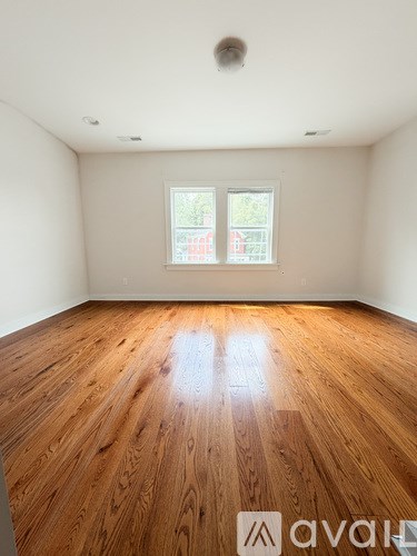 A room with wooden flooring and a window.