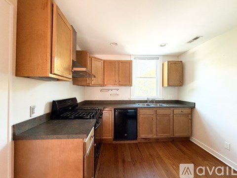 A kitchen with wooden cabinets and a black stove top.
