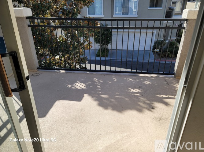 A view from a doorway looking out to a driveway and a house.