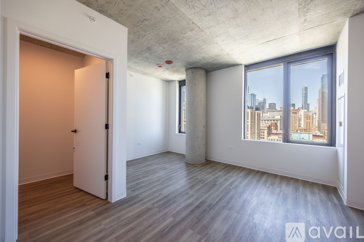 A spacious room with a view of the city skyline through the windows.
