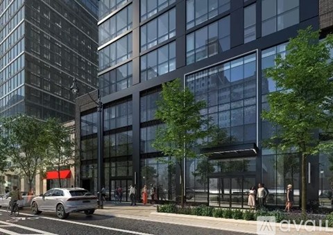 A modern building with a glass facade and a tree in front of it.