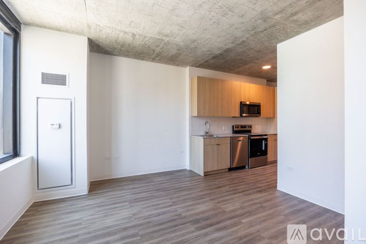 A kitchen with wooden floors and a white wall.
