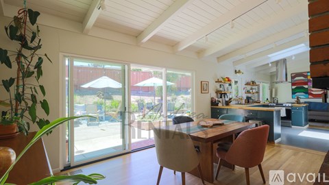 A kitchen with a table and chairs in front of a window.