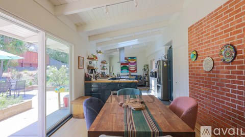 A dining room with a wooden table and chairs.