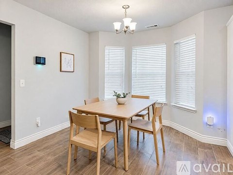 A dining room with a wooden table and chairs.