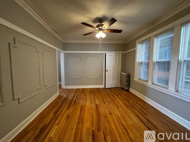 A room with wooden floors and a ceiling fan.