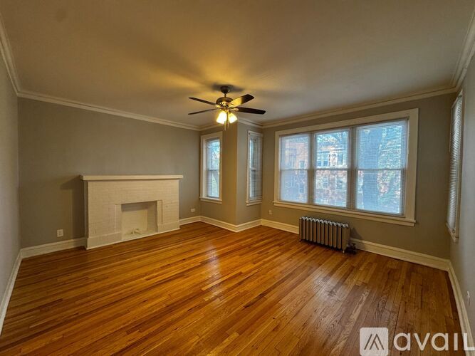 A room with a fireplace and wood flooring.