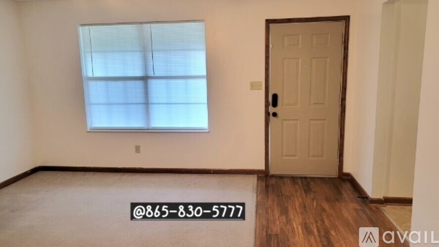A room with a door and a window with blinds.