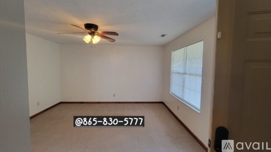 A room with a ceiling fan and a window.