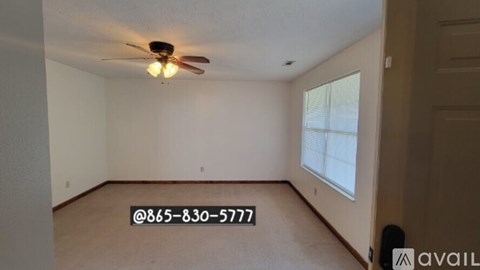A room with a ceiling fan and a window.