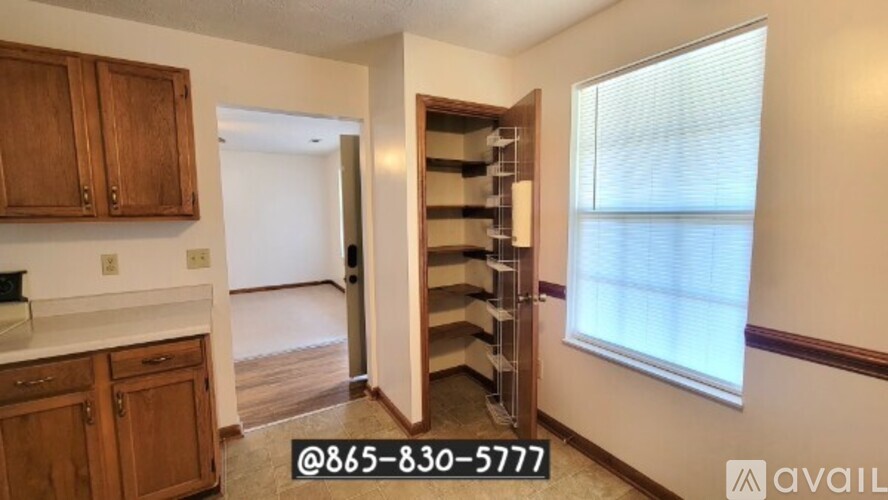 A kitchen with wooden cabinets and a white countertop is shown.