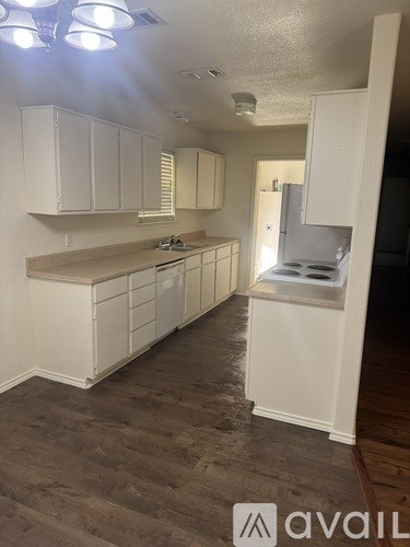 A kitchen with white cabinets and a countertop.