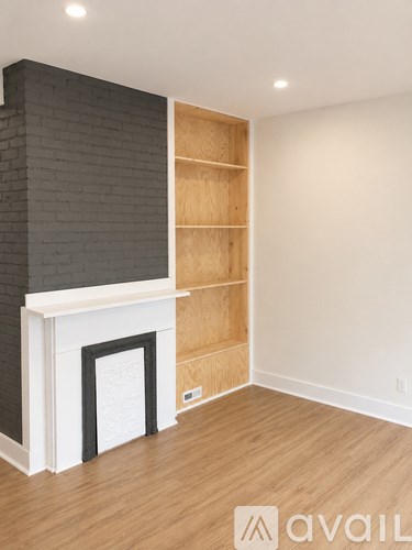 A room with a fireplace and wooden shelves.