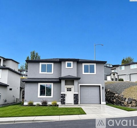 A modern house with a grey exterior and a white garage door.