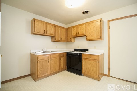 A kitchen with wooden cabinets and appliances.
