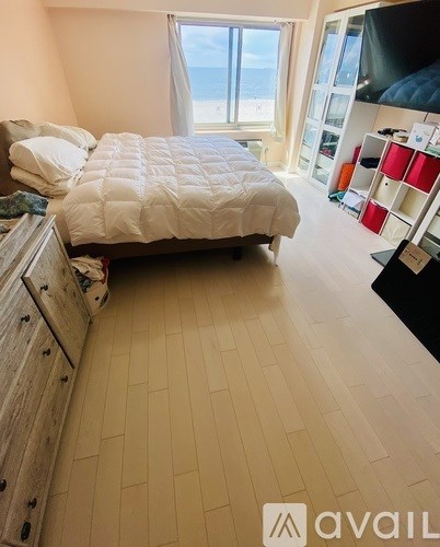 A bedroom with a large bed and a dresser.