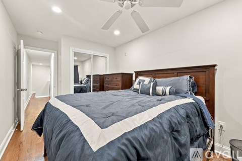 A bedroom with a large bed and a ceiling fan.