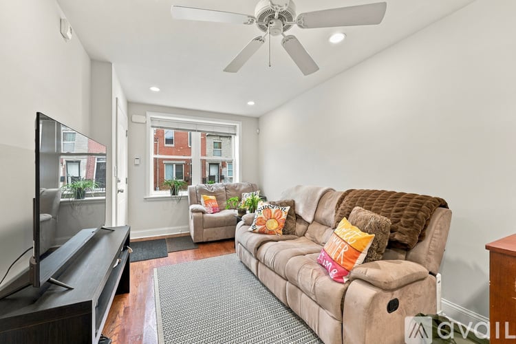 A living room with a brown couch and a flat screen TV.