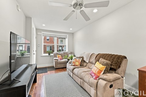 A living room with a brown couch and a flat screen TV.