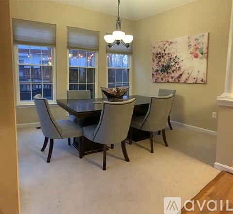 A dining room with a table and chairs.